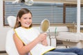 Little girl holding mirror in dentists chair Royalty Free Stock Photo