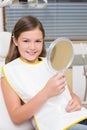 Little girl holding mirror in dentists chair Royalty Free Stock Photo