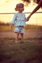 Little girl holding moms hand on a ranch