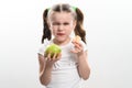 A little girl is holding one apple and chips on a white background. Royalty Free Stock Photo