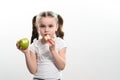 A little girl is holding one apple and chips on a white background. Royalty Free Stock Photo
