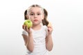 A little girl is holding one apple and chips on a white background. Royalty Free Stock Photo