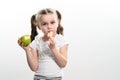 A little girl is holding one apple and chips on a white background. Royalty Free Stock Photo