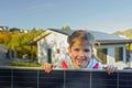 Little girl holding photovoltaics solar panel. Alternative energy, saving resources and sustainable lifestyle concept.