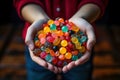 A little girl holding pile of candy in hands