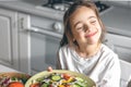 Little girl holding a plate with fresh vegetable salad, healthy eating concept. Royalty Free Stock Photo