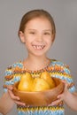 Little girl holding plate of yellow pears