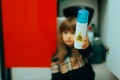 Little Girl Holding a Poisonous Substance from the Detergents Cabinet. Royalty Free Stock Photo