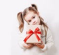 Little girl holding present box wrapped in kraft paper with big red bow. Christmas, new year or birthsday concept