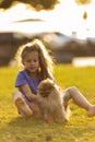 Little girl holding puppies. Child with pet dog. Family and pets on park lawn. Kid and animals friendship