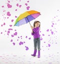 Little girl holding rainbow umbrella in storm of pink hearts Royalty Free Stock Photo