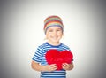 Little girl holding a red heart toy. Royalty Free Stock Photo