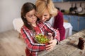 Granddaughter with grandmother mixing salad in the kitchen. Royalty Free Stock Photo