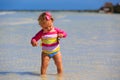 Little girl holding starfish at summer beach Royalty Free Stock Photo
