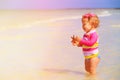 Little girl holding starfish at summer beach Royalty Free Stock Photo