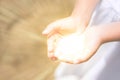 Little girl holding the sun in her hands. bright light comes from the hands of a child. concept miracle, magic Royalty Free Stock Photo
