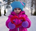 Little girl holding in their hands hearts themes Valentine`s day , the day of the winter on the street in the Park