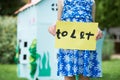 Little Girl Holding To Let Sign Outside Play House