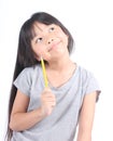 Little girl holding yellow pencil, thinking