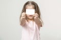Little girl holds a card in front of her and smile, portrait, copy space Royalty Free Stock Photo
