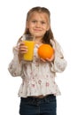 Little Girl Holds a Glass with an Orange Juice with One Hand and Royalty Free Stock Photo
