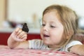 Little girl holds on the hand the Aglais io butterfly and watches for him, observation, emotions Royalty Free Stock Photo