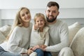 Little girl holds the keys to a new family home in her hands. Portrait of a smiling young married couple and a cute girl Royalty Free Stock Photo