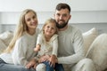 Little girl holds the keys to a new family home in her hands. Portrait of a smiling young married couple and a cute girl Royalty Free Stock Photo