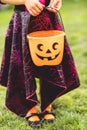 Little girl holds an orange jack o lantern trick or treat candy bucket