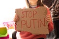 A little girl holds a poster with the words stop Putin at her home in Ukraine and asks to stop the war in Ukraine, the children