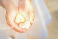 Little girl holds a shining heart in her hands. Light in the hands of a child. Concepts of miracle, magic, sharing, giving, Royalty Free Stock Photo