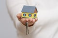 A little girl holds a toy house and a bunch of keys in her hand. Royalty Free Stock Photo