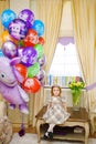 little girl at home with balloons. Inflatable hero of the Russian cartoon Luntik