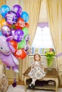 little girl at home with balloons. Inflatable hero of the Russian cartoon Luntik