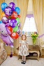 little girl at home with balloons. Inflatable hero of the Russian cartoon Luntik