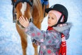 Little girl on a horse in winter, horseback riding Royalty Free Stock Photo