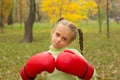 A little girl in huge boxing gloves makes an evil face. Royalty Free Stock Photo