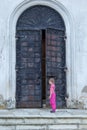 Little girl at the huge metal doors to temple Royalty Free Stock Photo