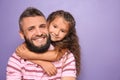 Little girl hugging her father on color background Royalty Free Stock Photo