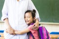 Little Girl hugging her mother in classroom