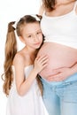 Little girl hugging her mother's pregnant belly Royalty Free Stock Photo