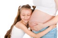 Little girl hugging her mother's pregnant belly Royalty Free Stock Photo