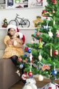 Little girl hugging her teddy bear looking at Christmas tree at home Royalty Free Stock Photo