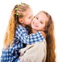 Little girl hugging and kissing her older sister Royalty Free Stock Photo