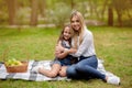 Little Girl Hugging With Mother Bonding On Picnic Outside