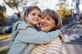 Little girl hugging smiling middle aged woman. Cute female kid and her grandmother enjoy walking outdoors Royalty Free Stock Photo