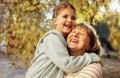 Little girl hugging smiling middle aged woman. Cute female kid and her grandmother enjoy walking outdoors Royalty Free Stock Photo