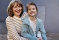 Little girl hugging smiling middle aged woman. Cute female kid and her grandmother enjoy walking outdoors Royalty Free Stock Photo