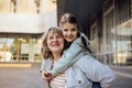 Little girl hugging smiling middle aged woman. Cute female kid and her grandmother enjoy walking outdoors Royalty Free Stock Photo