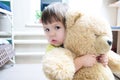 Little girl hugging teddy bear indoor in her room, big bear toy Royalty Free Stock Photo
